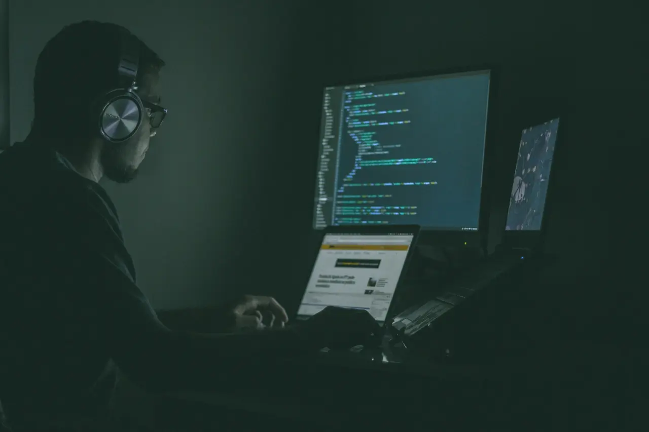 Person working at a laptop and computer screens